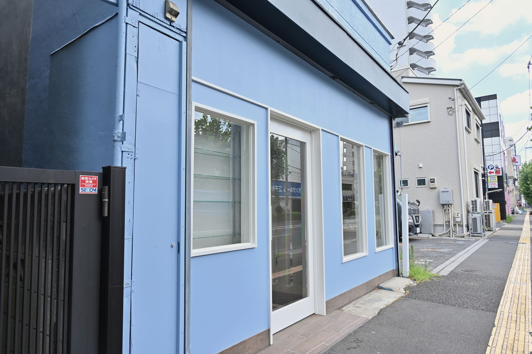 斜めから見た外観。青空と水色の壁